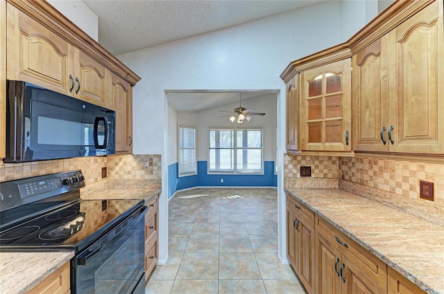 kitchen featuring lofted ceiling, light tile patterned floors, black appliances, light stone countertops, and a textured ceiling