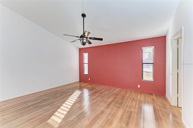 unfurnished room with ceiling fan, plenty of natural light, a textured ceiling, and light hardwood / wood-style floors