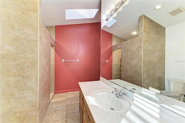 bathroom featuring vanity, walk in shower, toilet, tile patterned floors, and a textured ceiling