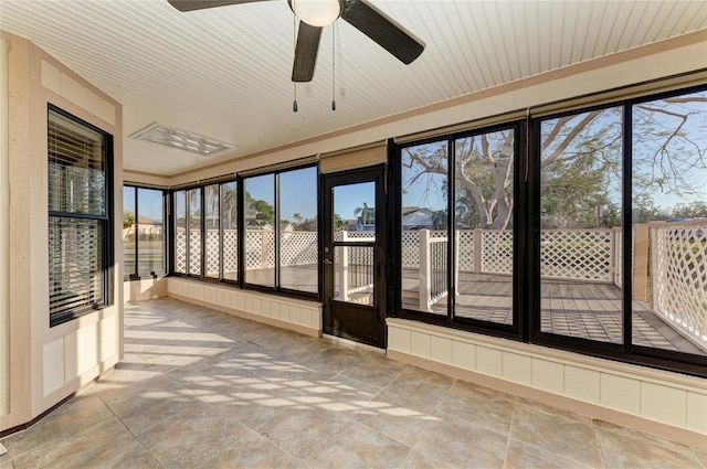 unfurnished sunroom featuring ceiling fan