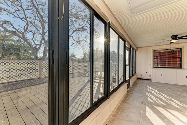 unfurnished sunroom featuring ceiling fan