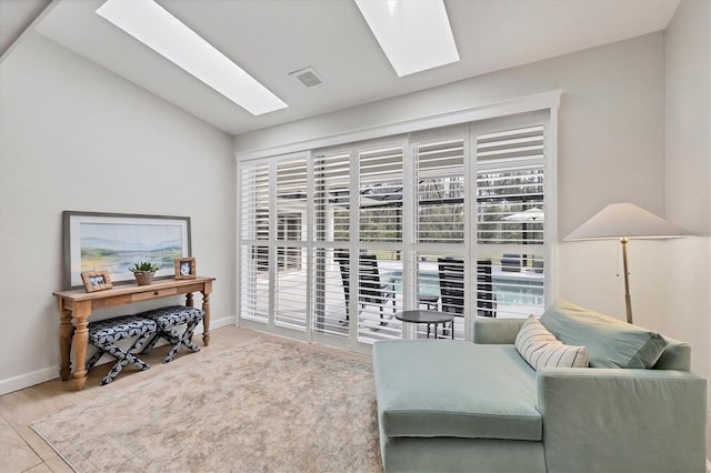 sitting room featuring vaulted ceiling with skylight