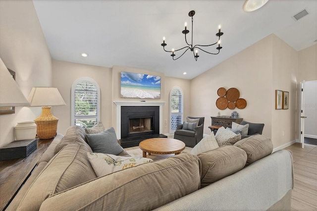 living room featuring lofted ceiling, a chandelier, and light wood-type flooring