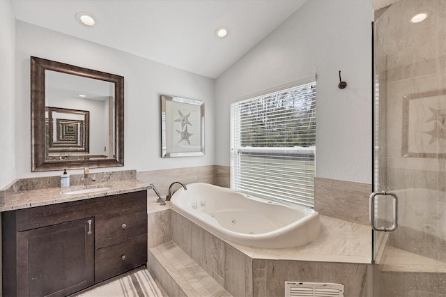 bathroom with vanity, shower with separate bathtub, and vaulted ceiling