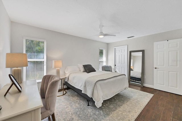 bedroom with dark wood-type flooring, a closet, and ceiling fan