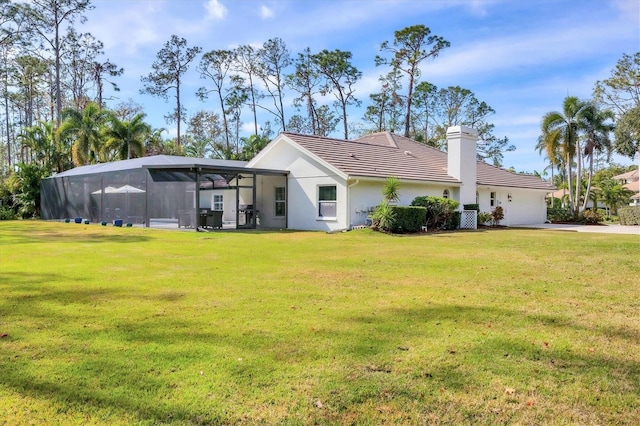 rear view of house featuring a lanai and a lawn