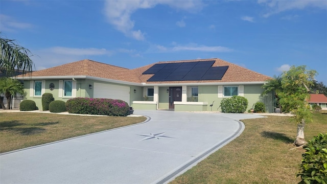 ranch-style house with a garage, a front lawn, and solar panels