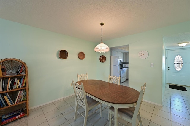 dining area featuring a textured ceiling and light tile patterned floors