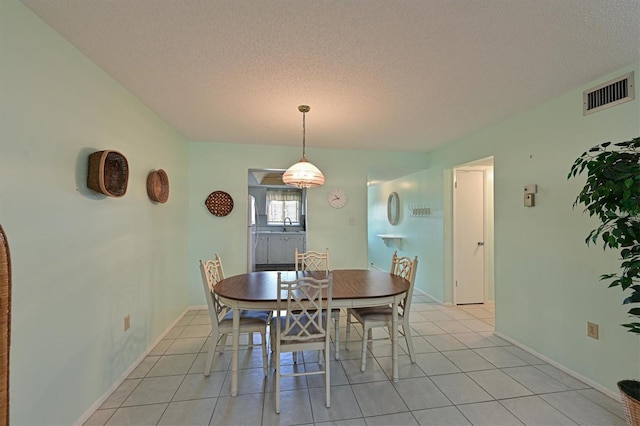 tiled dining area with a textured ceiling