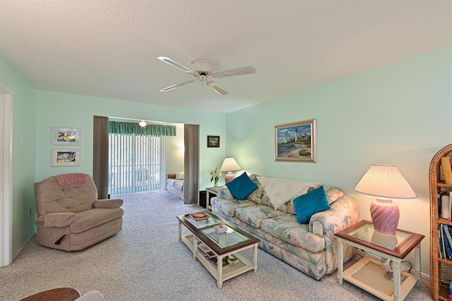 living room featuring ceiling fan, carpet floors, and a textured ceiling