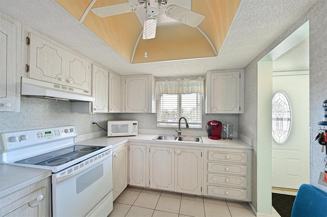 kitchen featuring a tray ceiling, sink, white appliances, and a textured ceiling