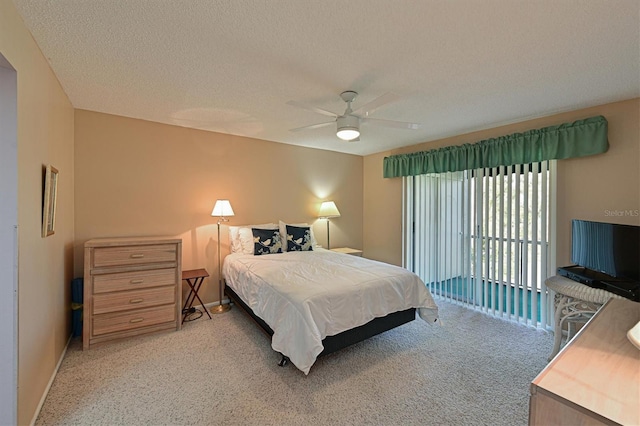 carpeted bedroom featuring ceiling fan and a textured ceiling