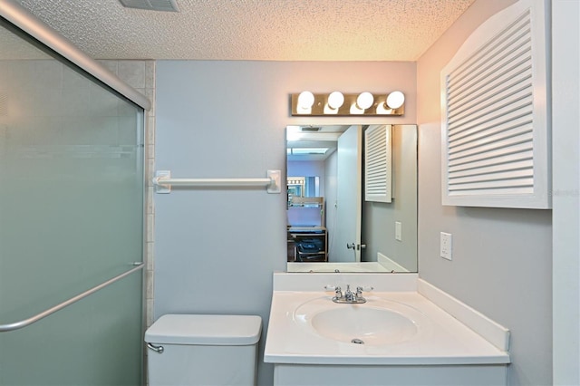 bathroom with vanity, toilet, a textured ceiling, and walk in shower