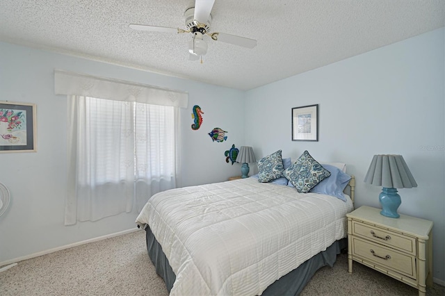 carpeted bedroom featuring ceiling fan and a textured ceiling