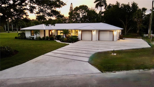 view of front of home with a garage and a yard