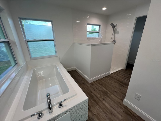 bathroom featuring wood-type flooring and shower with separate bathtub