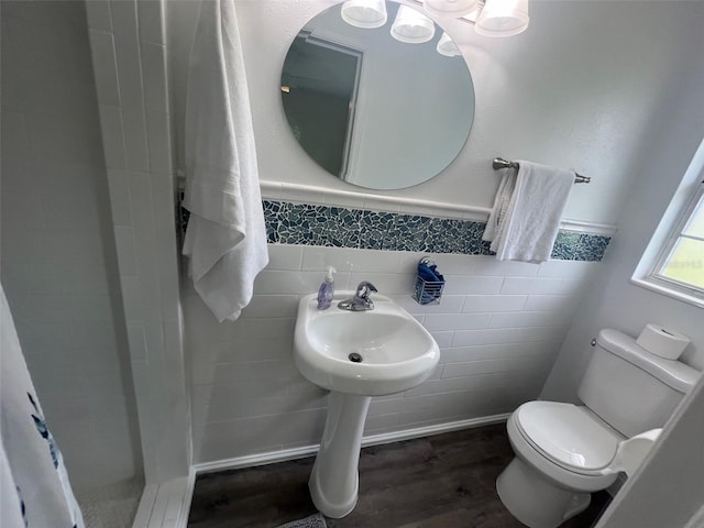 bathroom featuring tile walls, wood-type flooring, and toilet