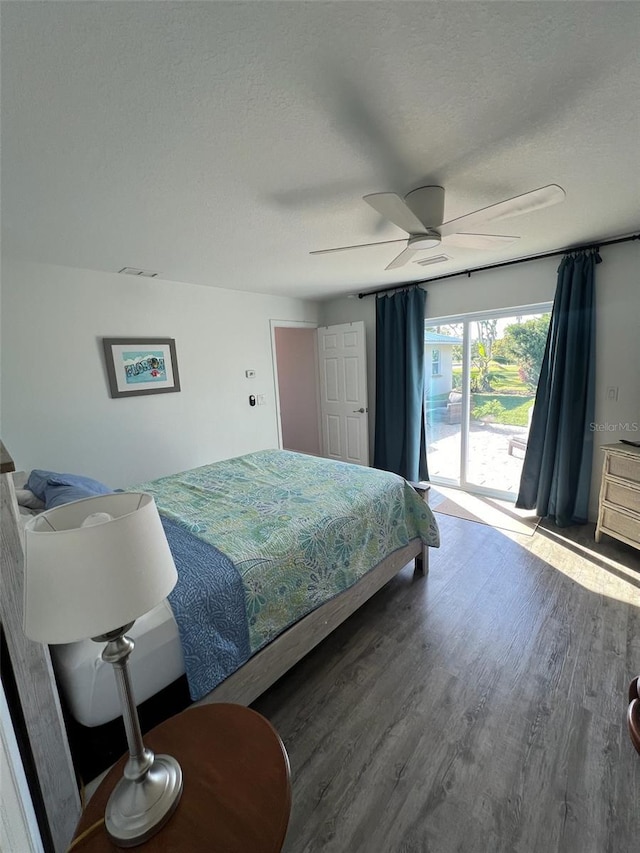 bedroom featuring access to exterior, wood-type flooring, a textured ceiling, and ceiling fan