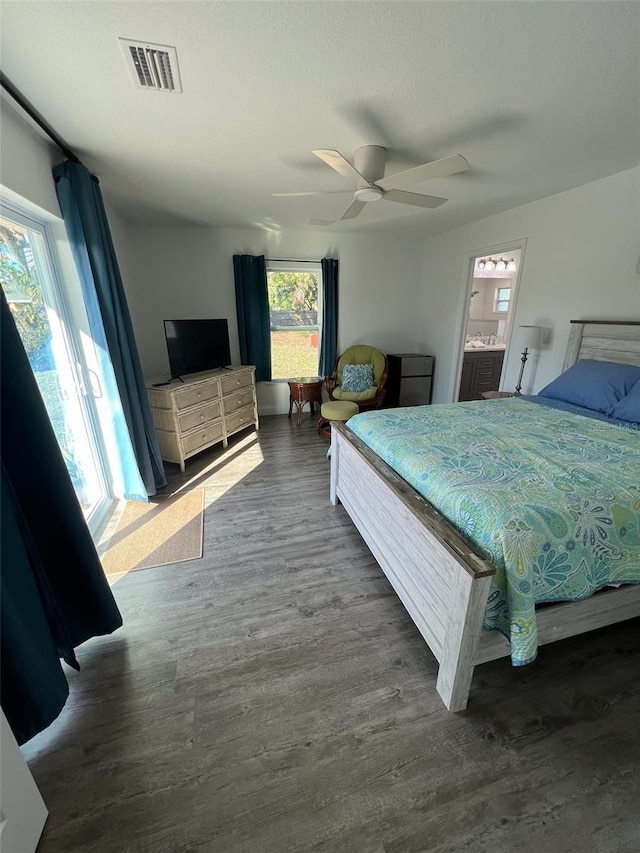 bedroom featuring dark hardwood / wood-style flooring, a textured ceiling, ceiling fan, and ensuite bathroom