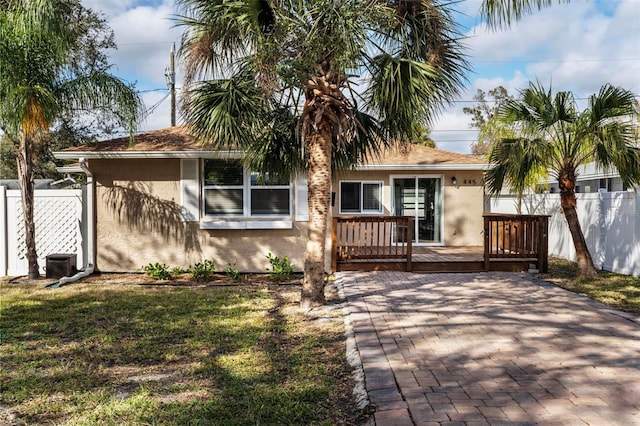 view of front facade featuring cooling unit, a front lawn, and a deck