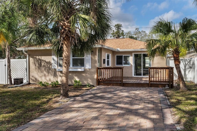 rear view of house featuring a deck and a lawn