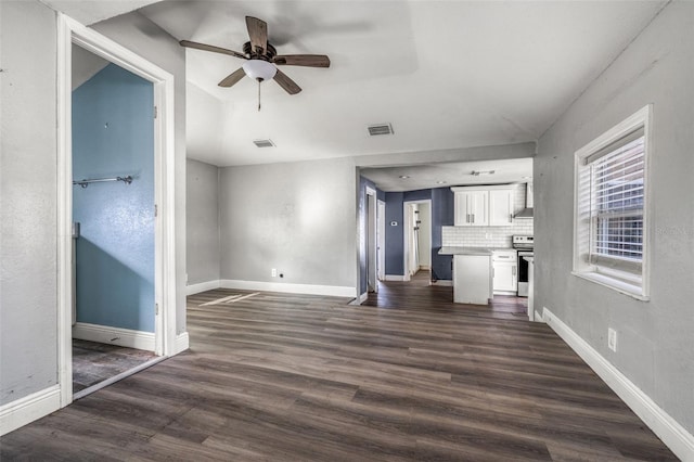 unfurnished living room featuring dark wood-type flooring and ceiling fan