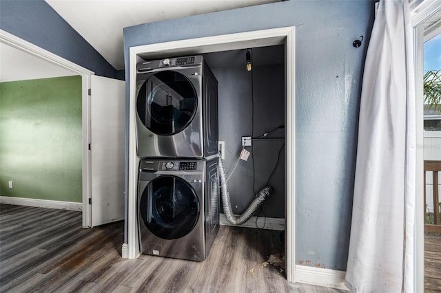 clothes washing area with stacked washer and dryer and dark hardwood / wood-style floors