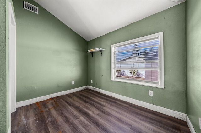 unfurnished room featuring vaulted ceiling and dark hardwood / wood-style floors