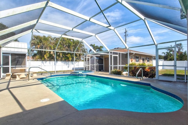 view of swimming pool with an in ground hot tub, glass enclosure, and a patio