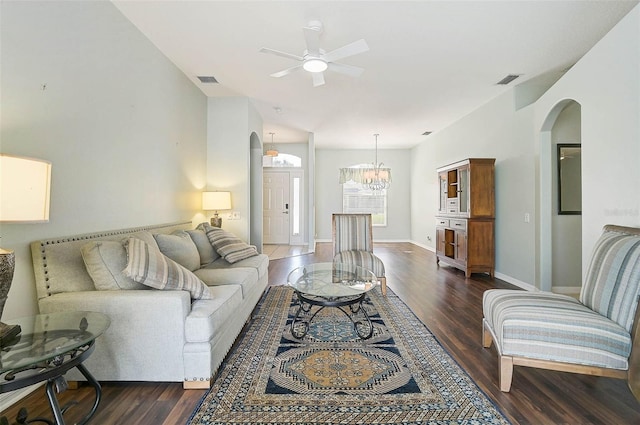 living room with vaulted ceiling, dark hardwood / wood-style floors, and ceiling fan with notable chandelier