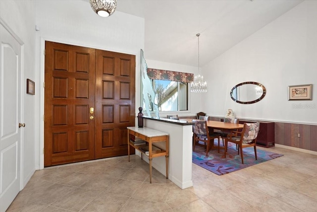 tiled foyer with an inviting chandelier and vaulted ceiling