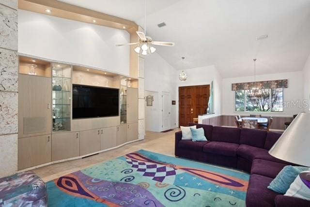 living room featuring ceiling fan with notable chandelier and high vaulted ceiling