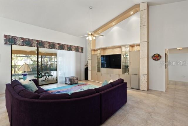 living room featuring high vaulted ceiling and ceiling fan