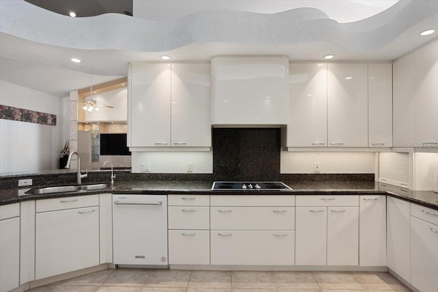 kitchen featuring black electric cooktop, sink, white cabinets, and backsplash