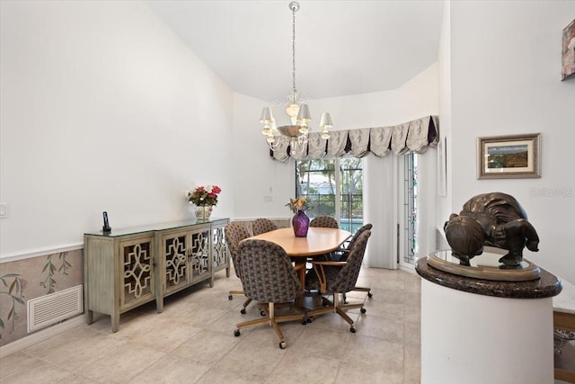 dining area with light tile patterned floors, vaulted ceiling, and a chandelier