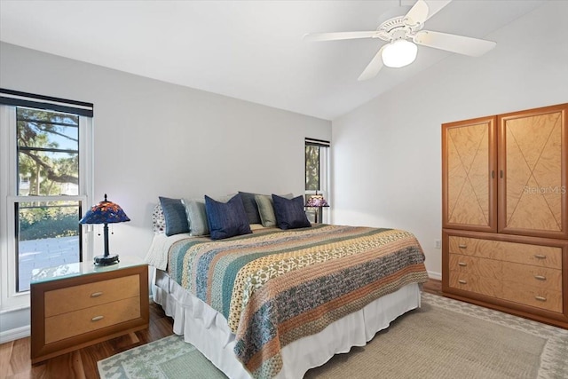 bedroom featuring ceiling fan, light hardwood / wood-style floors, and vaulted ceiling