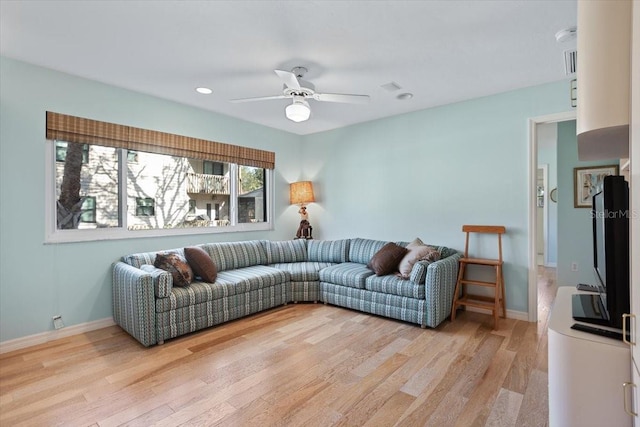 living room featuring ceiling fan and light hardwood / wood-style floors