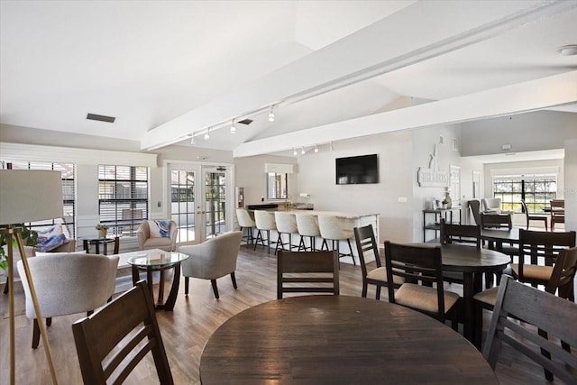 dining area with french doors, lofted ceiling, light hardwood / wood-style flooring, and plenty of natural light