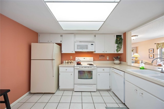 kitchen with white cabinetry, sink, light tile patterned floors, and white appliances