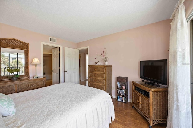 bedroom with wood-type flooring and a textured ceiling