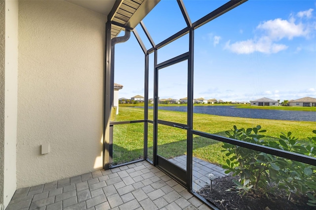 unfurnished sunroom featuring a water view