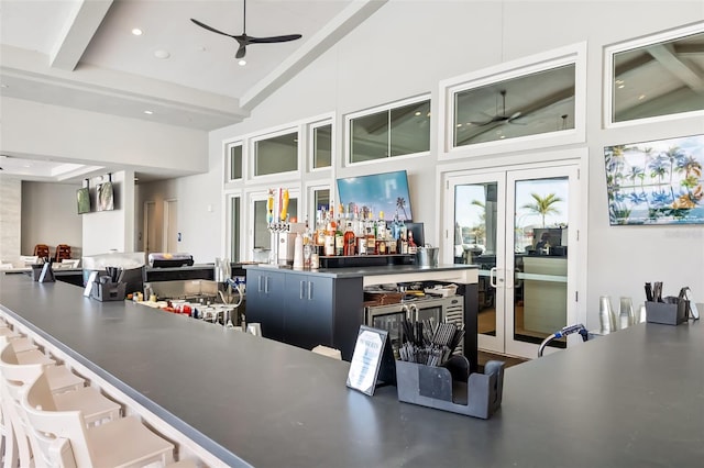 bar with french doors, ceiling fan, and high vaulted ceiling