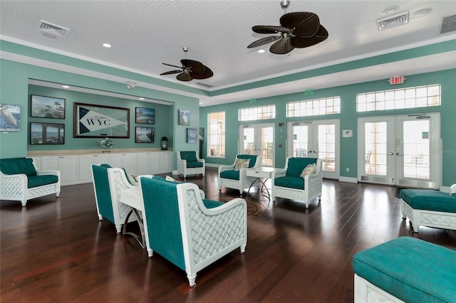 living room with french doors, ornamental molding, dark hardwood / wood-style flooring, a tray ceiling, and ceiling fan