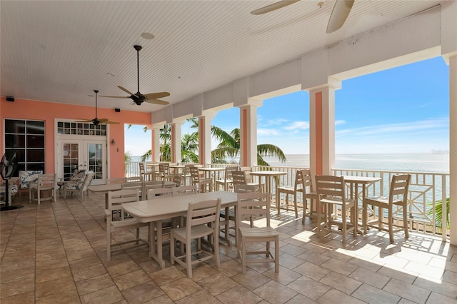 view of patio / terrace featuring a water view, ceiling fan, and french doors