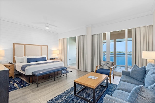 bedroom with a water view, light wood-type flooring, ornamental molding, ceiling fan, and access to exterior