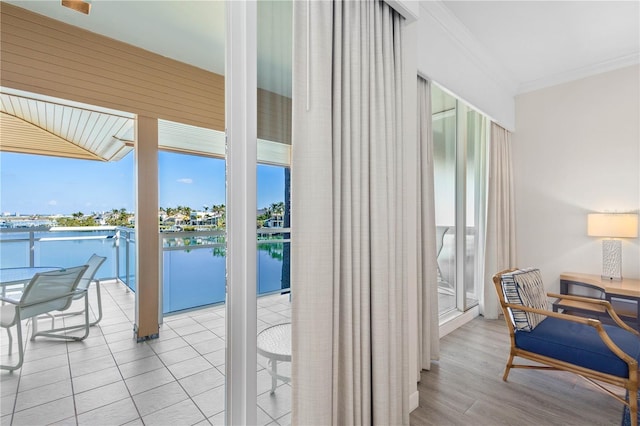 doorway to outside featuring a water view and crown molding