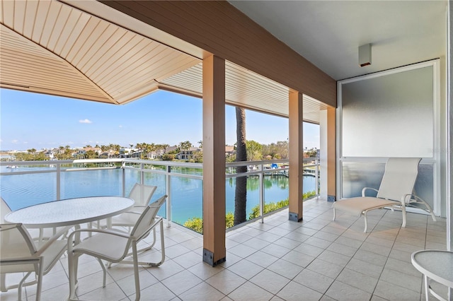 view of patio featuring a balcony and a water view