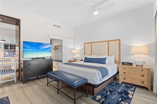 bedroom featuring ceiling fan, ornamental molding, and light hardwood / wood-style floors