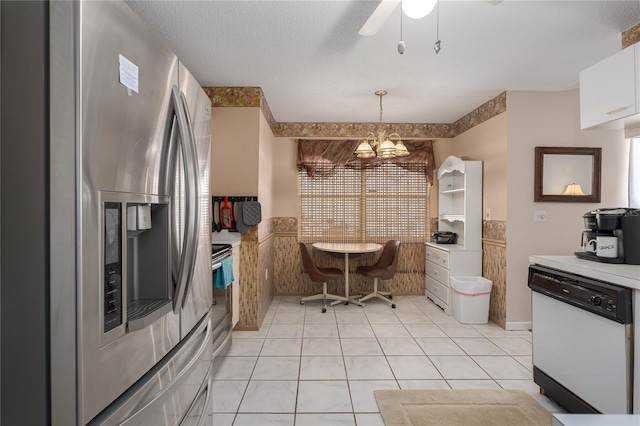 kitchen with light tile patterned flooring, a textured ceiling, appliances with stainless steel finishes, pendant lighting, and white cabinets