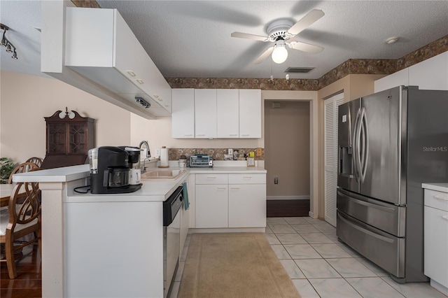 kitchen with sink, white cabinetry, a textured ceiling, kitchen peninsula, and stainless steel appliances